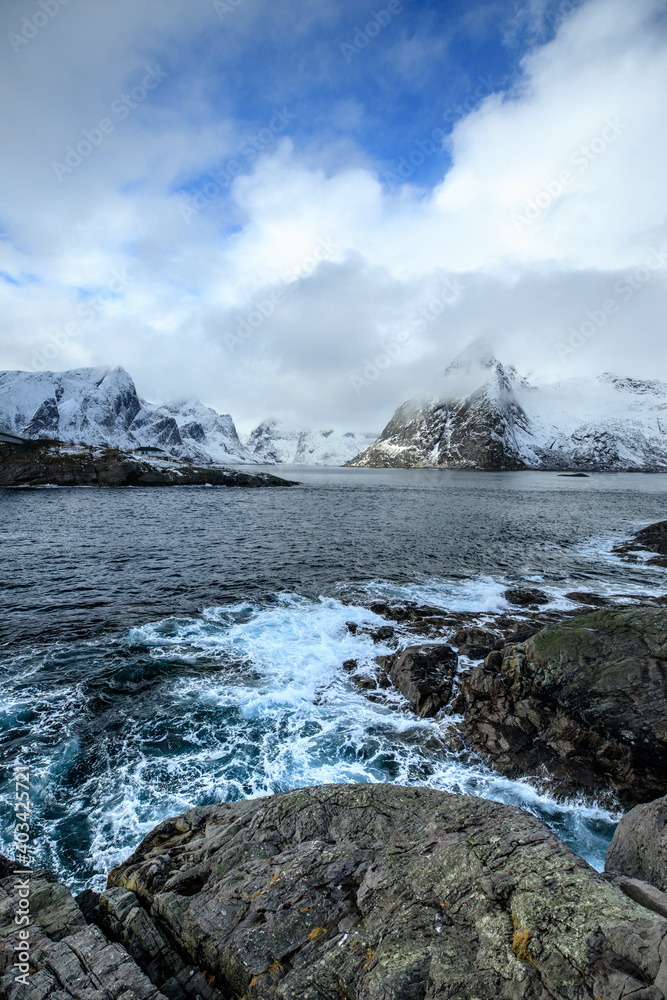 Beautiful landscape. Lofoten Islands. Sea and wave against the backdrop of mountains and clouds.