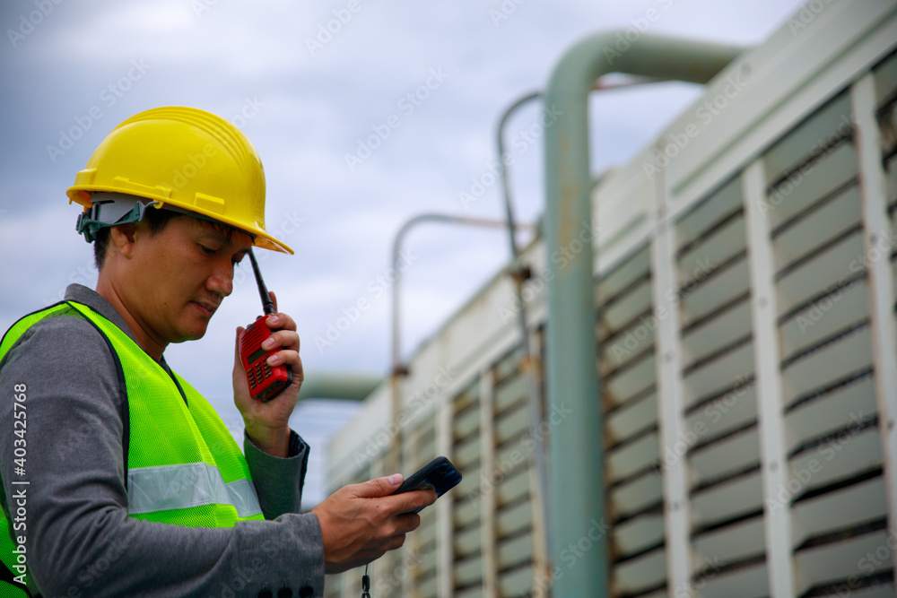 Engineer with safety helmet at the construction site typing on a digital tablet	