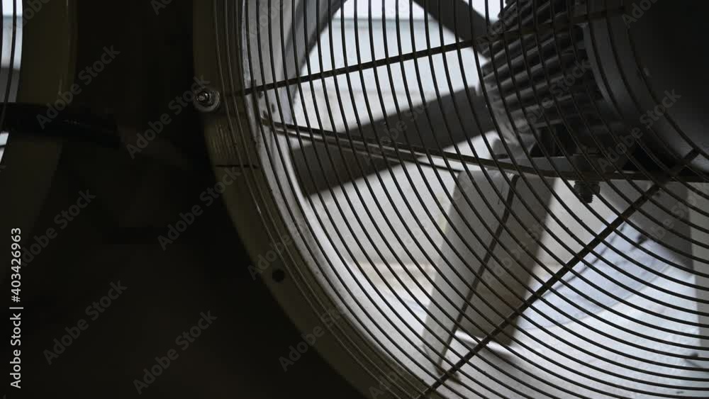 close-up view of dusty fan blades. Large fan with slow rotating blades.