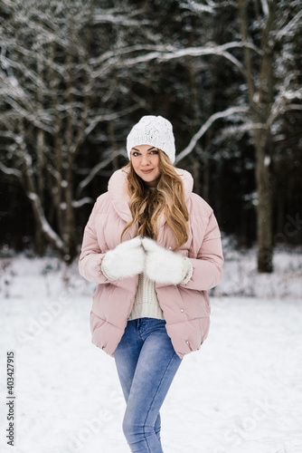young beautiful woman with long hair in winter clothes in a winter park smiling © Elena