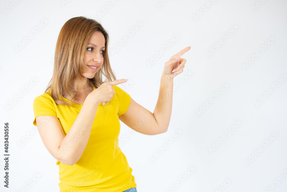 Happy young woman presenting with thumbs up over white background