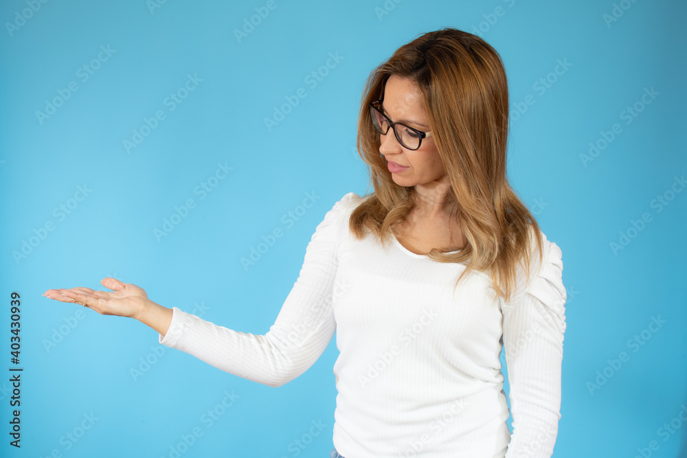 Happy young woman in glasses presenting something on the hand Happy young woman in glasses presenting something on the hand