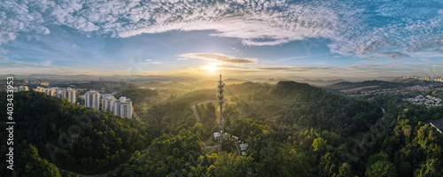 Panorama Aerial view of 5G Communication tower during beautiful sunrise with clouds, mists and fog