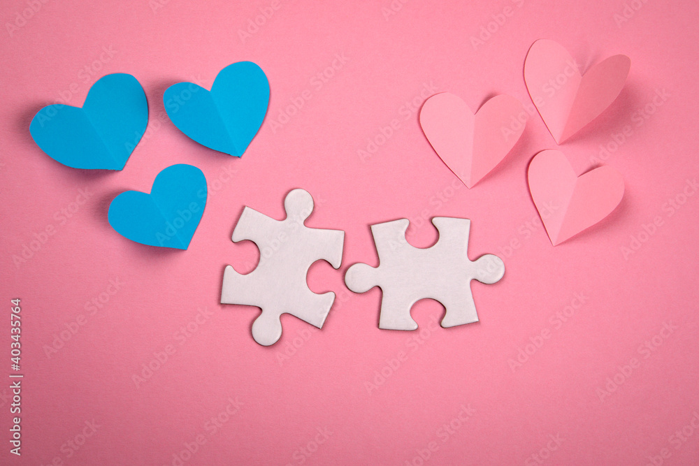Women and men union, lovers, relationships and family building concept. Paper hearts and puzzles on a pink background