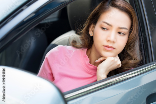 Young woman in the car showing upset expression because of traffic