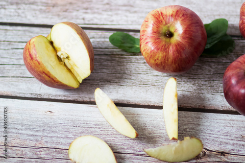 Large red apples lie on a wooden table