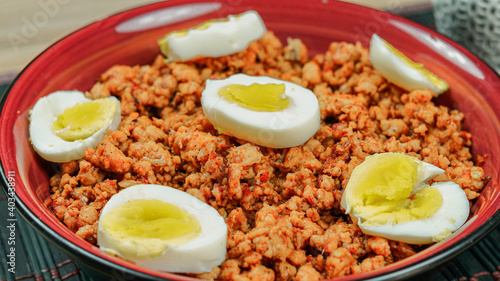 A closeup of Desi pakistani and indian chicken keema with boiled eggs pieces on the top. photo