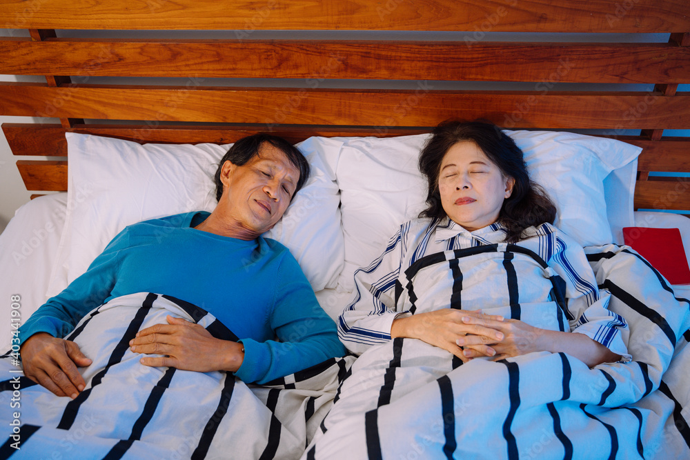 Senior couple sleeping together on a bed at night. Senior couple sleeping together on a bed at night.