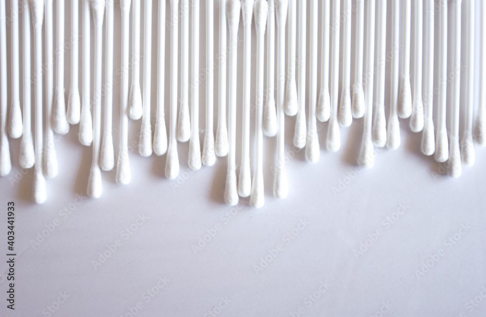 Close-up photo of white cotton swabs and white cotton swabs on isolated white background. Close-up photo of white cotton swabs and white cotton swabs on isolated white background.