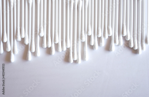 Close-up photo of white cotton swabs and white cotton swabs on isolated white background.