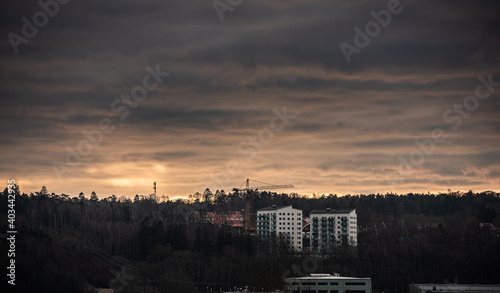 Construction crane and tall apartment buildings by a forest. © Trygve