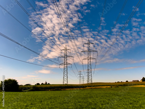 Hochspannungs-Freileitungen und Freileitungsmasten in ländlicher Umgebung an einem sonnigen Tag in der Nähe der Gemeinde Römerswil, Schweiz