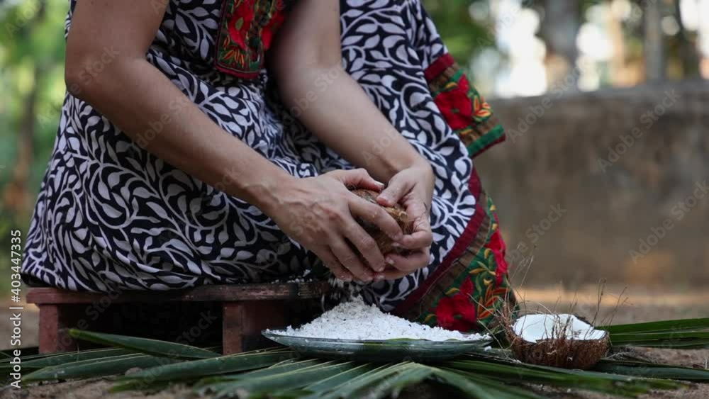 Woman hand grating fresh raw coconut cut open in half 4K slow motion video , footage of Indian