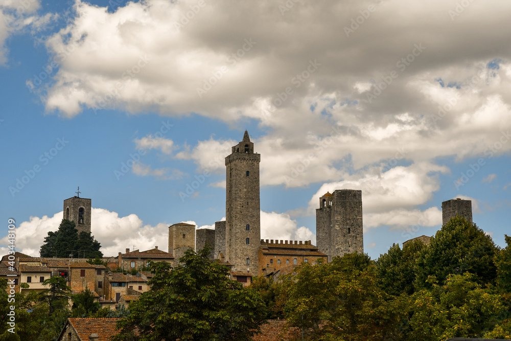 Elevated view of the historic centre of San Gimignano, Unesco World Heritage Site, with the famous medieval towers against blue cloudy sky, Siena, Tuscany, Italy