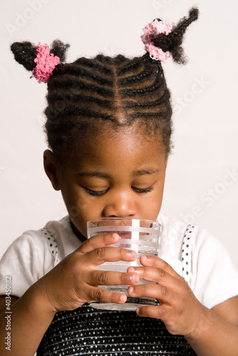 Kleines Rasta Mädchen mit Blick ins Wasserglas