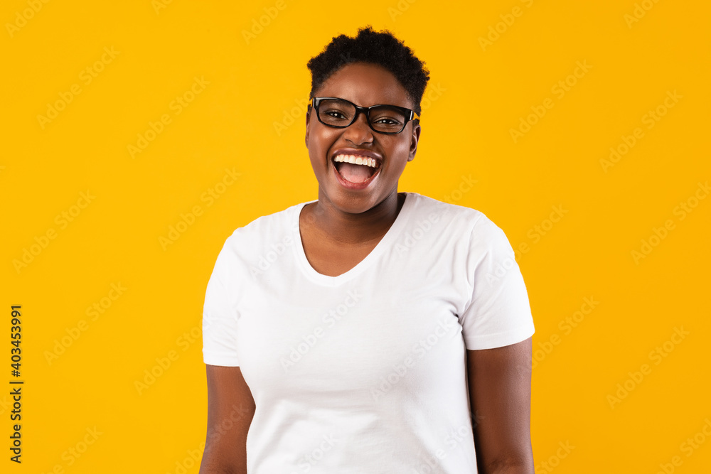 Happy Plus-Size African American Woman's Portrait Over Yellow Background