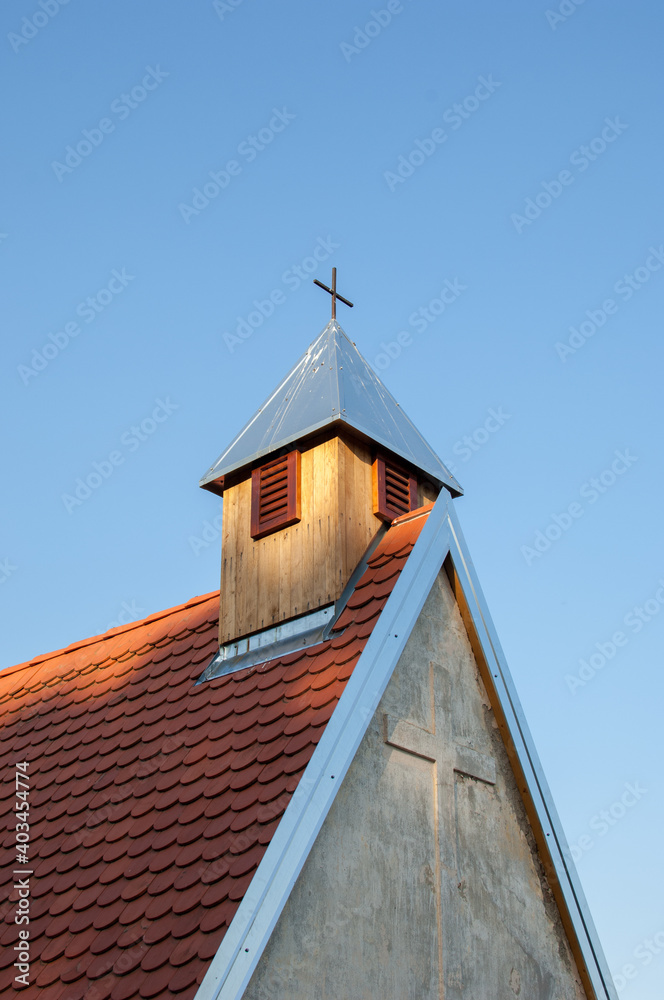 The roof of the old church and attic window with cross