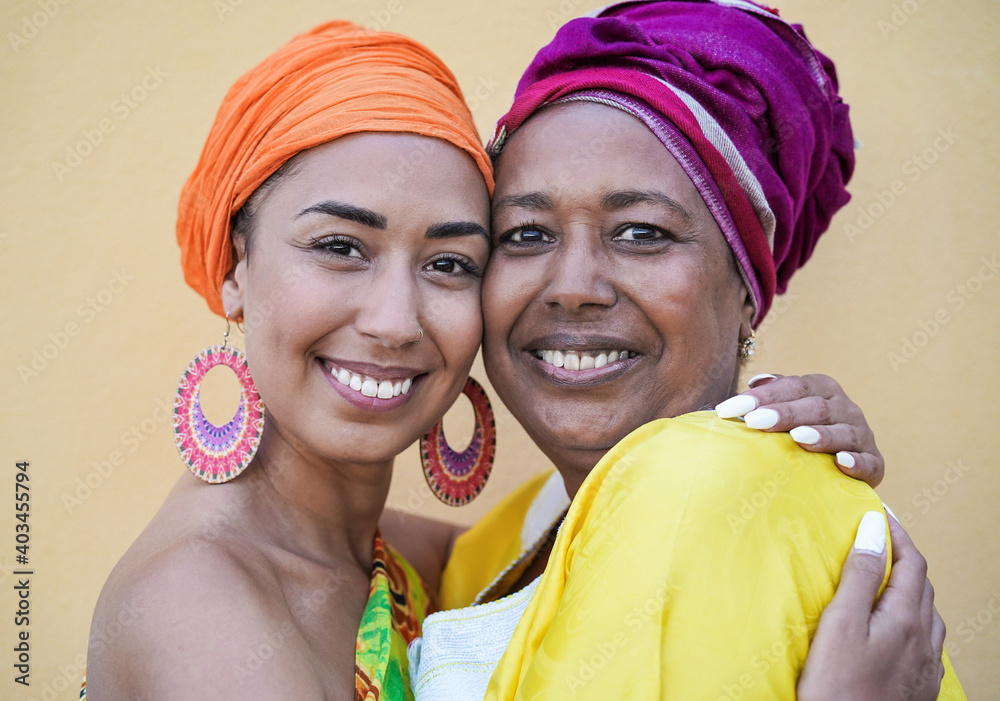 Portrait of happy african mother and adult daughter wearing traditional dress and turban - Family love and happiness concept Portrait of happy african mother and adult daughter wearing traditional dress and turban - Family love and happiness concept