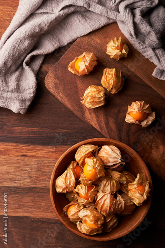 top view concept of cape gooseberry or physalis berry in a wooden bowl on a dining table in homemade style background with copy space 