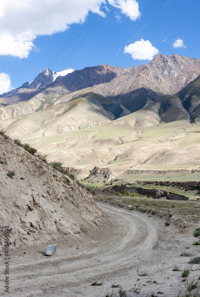 Picturesque mountain landscape with a sharp turn of the dirt road.