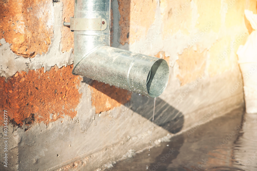 Sewer in the wall with flowing water after rain. Drain system Sewer in the wall with flowing water after rain. Drain system