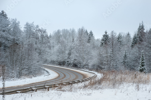 A road in the winter forest. Snow-covered landscape with a road.