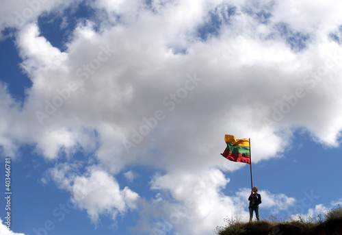 Young happy woman with Lithuanian flag, sky background photo