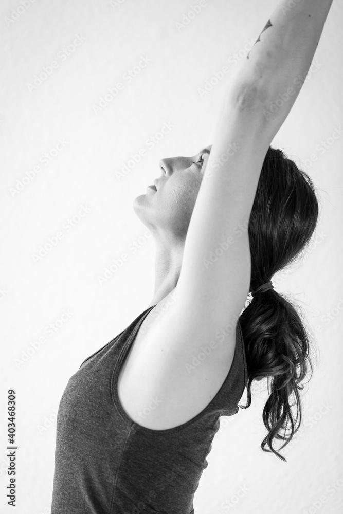Naklejka premium Side view detail of brunette woman stretching, doing the standing asana Crescent Lunge Pose - Anjaneyasana