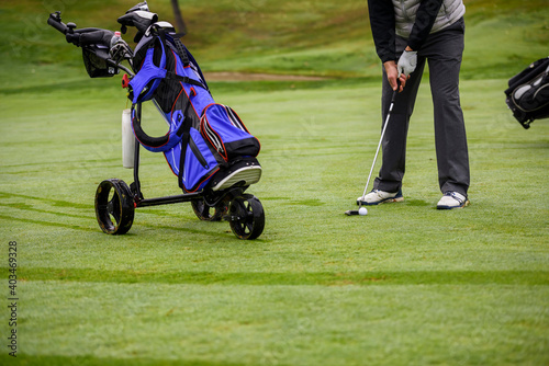 Close-up of a golf player who with a putt pocket the ball on the green