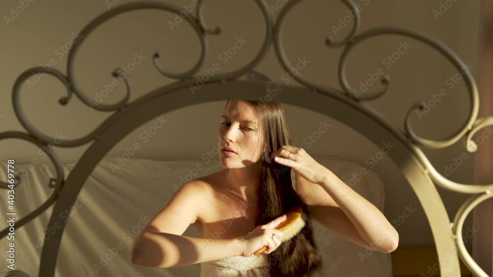 Medium shot of brunette girl brushing hair in front of the mirror Medium shot of brunette girl brushing hair in front of the mirror