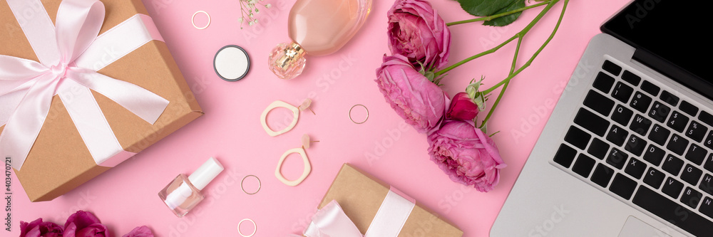 Banner with gift, laptop, flowers, feminine cosmetics and accessories on a pink background. Online celebrate or shopping concept. - obrazy, fototapety, plakaty 