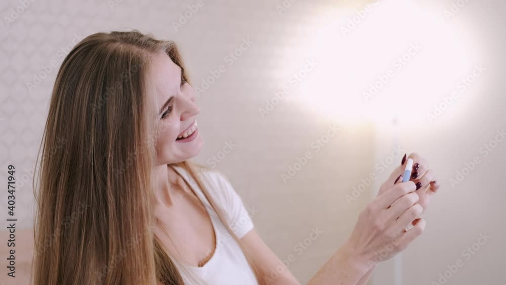Happy future mother smiles broadly when finds out positive results of pregnancy test, cant believe in such good news, poses against cozy domestic background. Happy future mother smiles broadly when finds out positive results of pregnancy test, cant believe in such good news, poses against cozy domestic background.