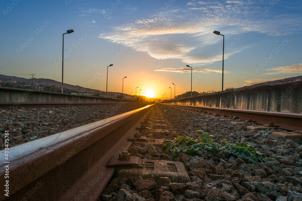 railway in the countryside and sunset, Railroad and station, On the sides are lighting poles ( Lamppost ), railway