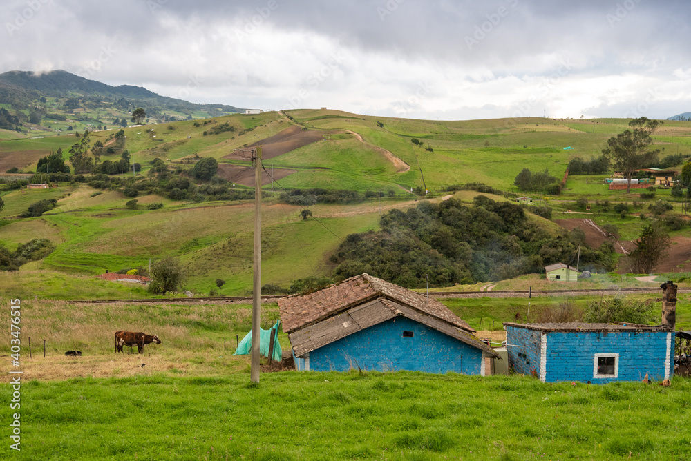 Old blue country house in a country landscape in Boyaca with mountains in the background. Colombia