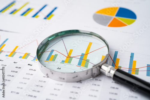 Magnifying glass on charts graphs paper. Financial development, Banking Account, Statistics, Investment Analytic research data economy, Stock exchange trading, Business office company meeting concept.