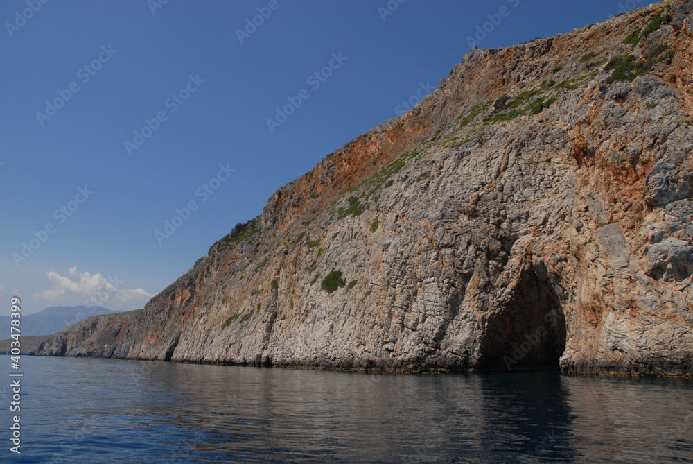 Coastline with cave in cliff an blue sky