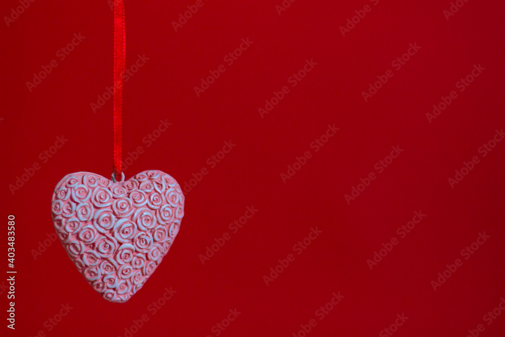 pink heart of roses on a ribbon on a red background. Space for notes and inscriptions pink heart of roses on a ribbon on a red background. Space for notes and inscriptions