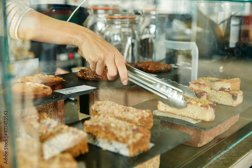 Close up of tongs selecting a slice of cake in cafe photo