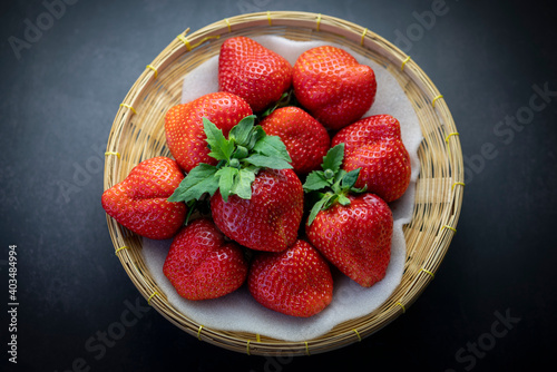 Fresh strawberries in a wooden bowl on  black table  Red Strawberries in Bamboo basket.
