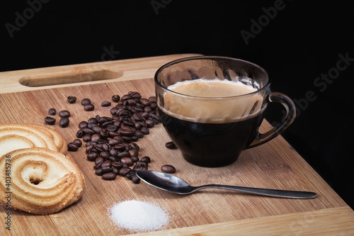 Duble espresso coffe with some beans and delicious cookies.