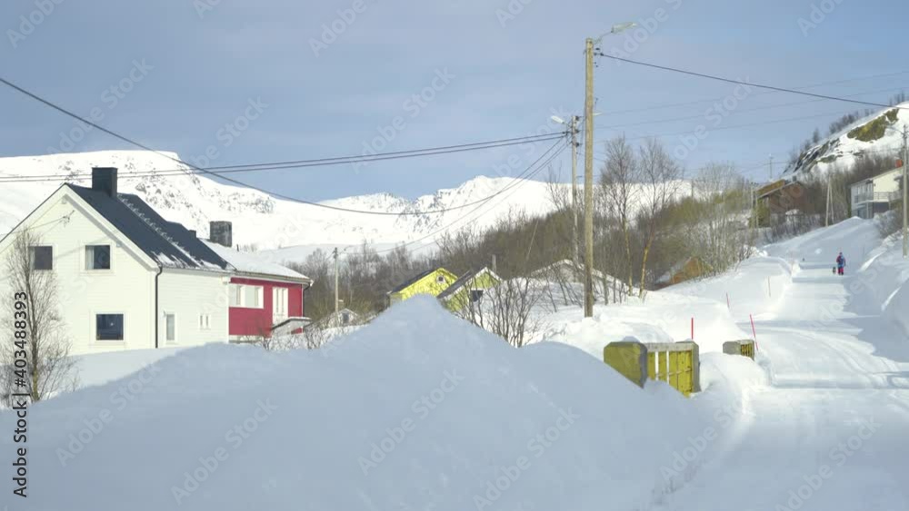 Person walking in snow in a idyllic village far up in Northern Norway - Bergsfjord Spring 2020 Person walking in snow in a idyllic village far up in Northern Norway - Bergsfjord Spring 2020