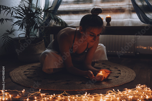 Self-care, self-compassion, mental wellbeing in post-pandemic world. Mental health, wellbeing, meditation to eliminate anxiety. Young woman sitting on floor do yoga exercise and meditation at home photo