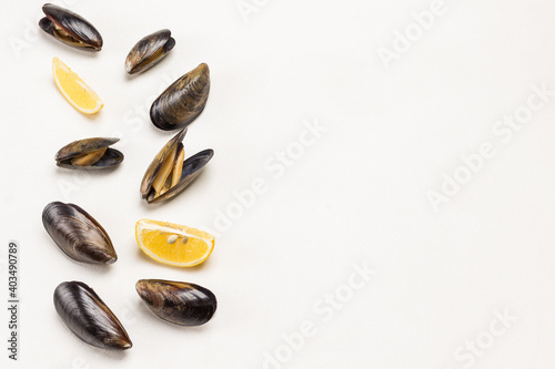 Mussels with open shells and lemon on white background