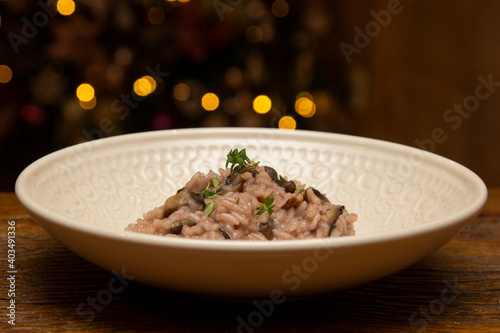 Mushroom risotto on the wooden table on christmas background.