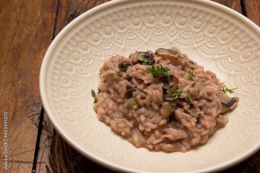 Mushroom risotto, on the wooden table.