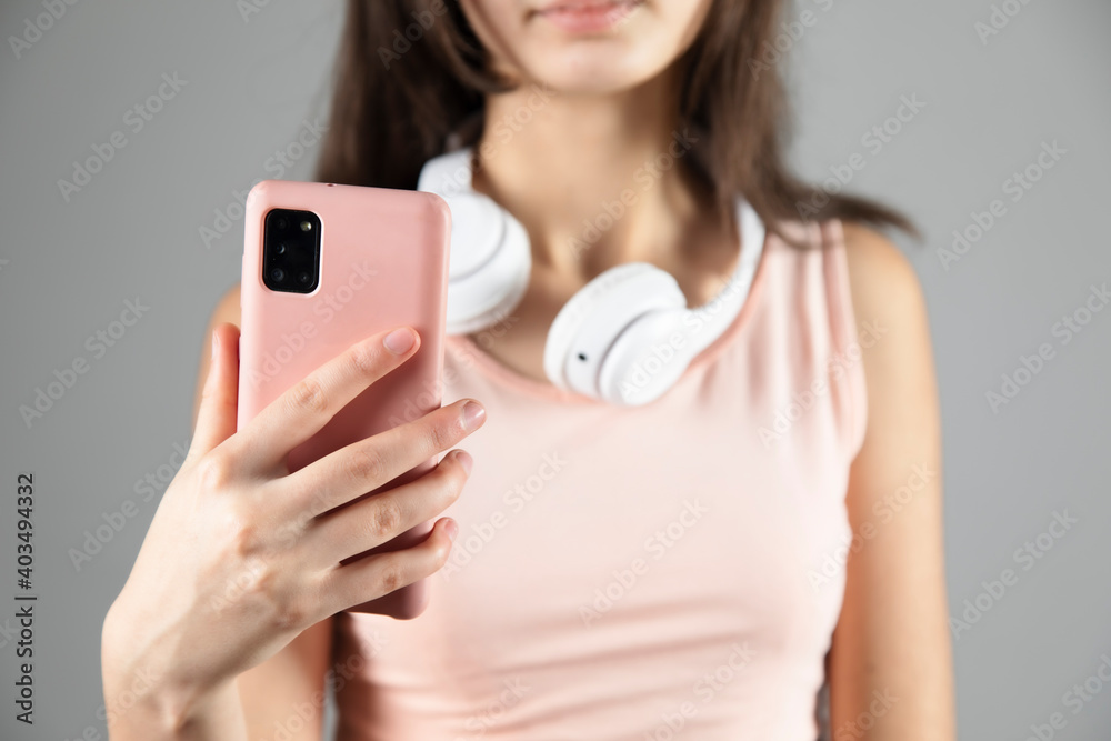 The woman holding phone with headphones The woman holding phone with headphones
