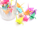 Closeup of origami paper cranes with glass cup