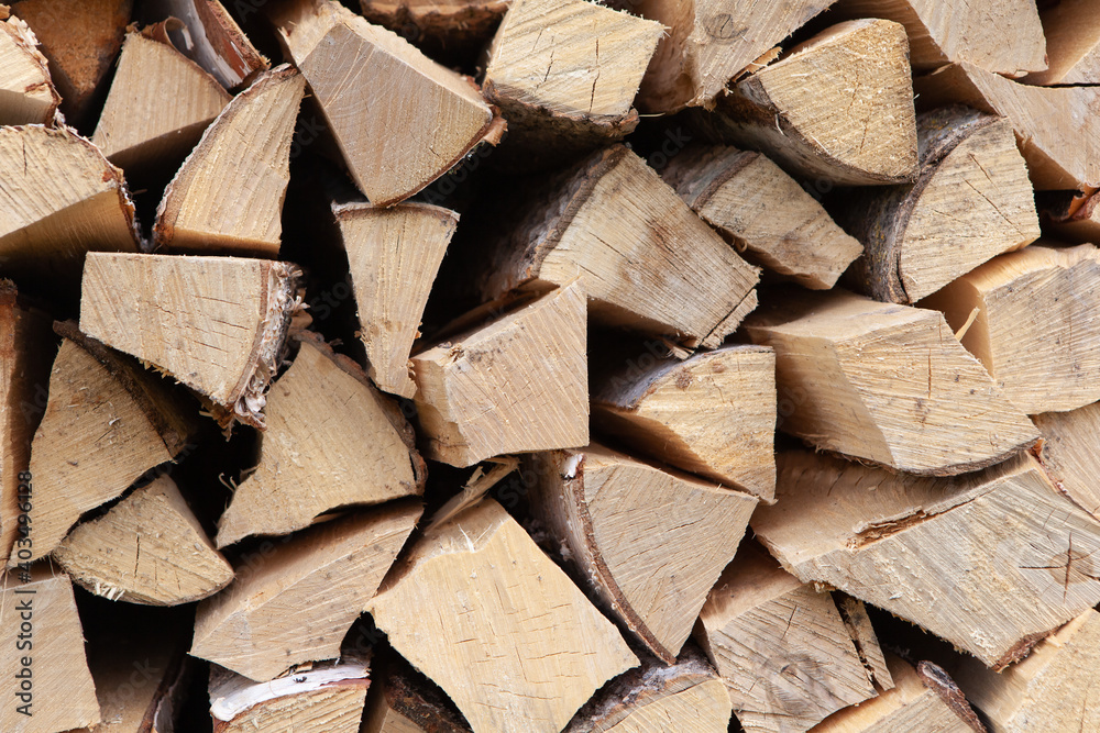 Background from a stack of firewood for heating a house, stacked in the backyard, uncut wood, birch. Concept for eco-friendly home heating during the cold season. Overall plan. Horizontal Background from a stack of firewood for heating a house, stacked in the backyard, uncut wood, birch. Concept for eco-friendly home heating during the cold season. Overall plan. Horizontal