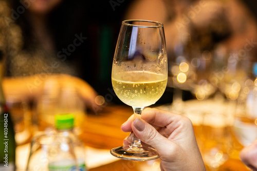 Female hand holding glass of sparkling wine.