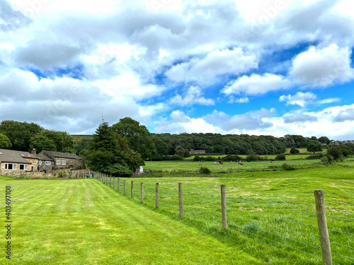 Landscape, with extensive meadows, farm buildings, and trees on the horizon near, Bingley, Bradford, UK